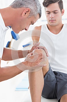 Doctor examining his patient knee