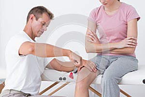 Doctor examining his patient knee