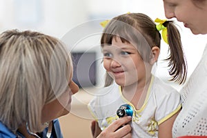 Doctor examining kid with stethoscope in clinic. Children health concept