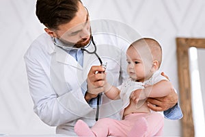 Doctor Examining Little Baby Listening To Child& x27;s Heartbeat In Clinic