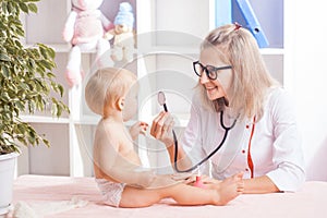 Doctor examining little baby with stethoscope in clinic. Baby health concept