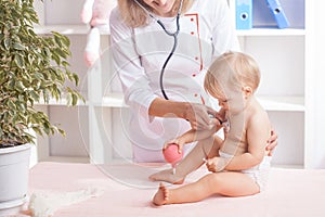 Doctor examining little baby with stethoscope in clinic. Baby health concept