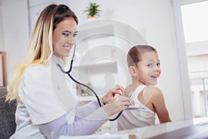 Doctor examining a little boy by stethoscope