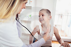 Doctor examining a little boy by stethoscope