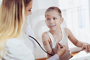 Doctor examining a little boy by stethoscope