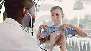 Doctor examining little boy by stethoscope.