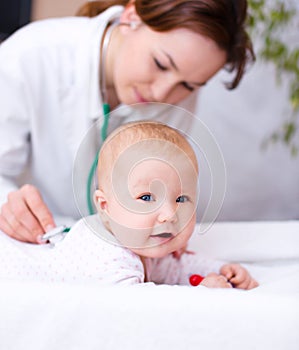 Doctor is examining little child