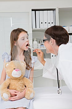 Doctor examining little girl mouth