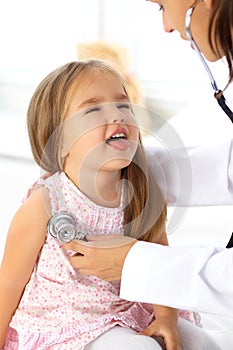 Doctor examining a little girl by stethoscope