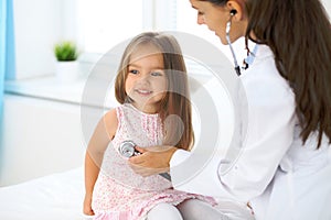 Doctor examining a little girl by stethoscope