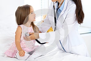 Doctor examining a little girl by stethoscope