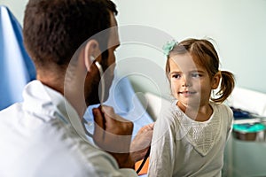 Doctor examining little girl with stethoscope in hospital. Healthcare, child, pediatrician concept.