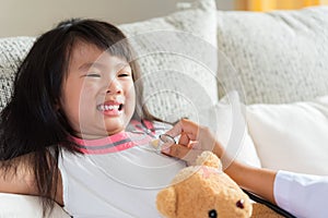 Doctor examining a little girl by using stethoscope