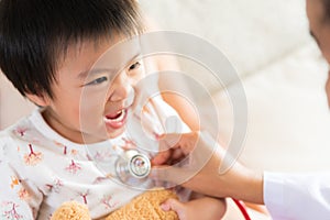 Doctor examining a little girl by using stethoscope.