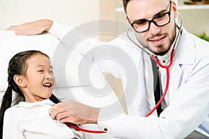 Doctor examining little happy kid in hospital.