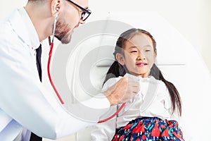 Doctor examining little happy kid in hospital.