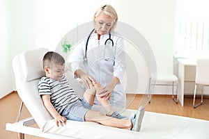 Doctor examining little patient with knee problem