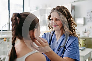 Doctor examining lymp nodes on neck of the young girl. Palpation of lymph nodes. Concept of preventive health care for photo