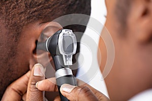 Doctor Examining Male Patient`s Ear photo
