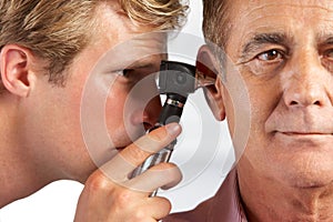 Doctor Examining Male Patient's Ears