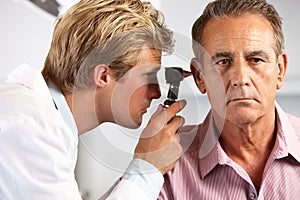 Doctor Examining Male Patient's Ears