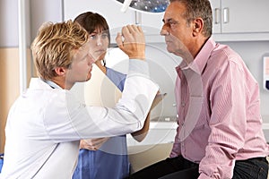 Doctor Examining Male Patient's Eyes