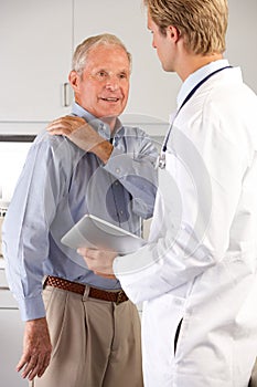 Doctor Examining Male Patient With Shoulder Pain