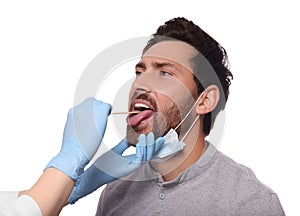 Doctor examining man`s oral cavity with tongue depressor on white background