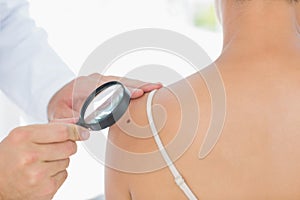 Doctor examining melanoma on woman