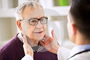 Doctor examining old patient lymph glands