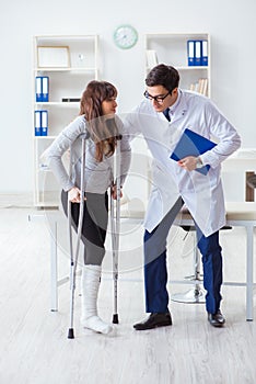 The doctor examining patient with broken leg