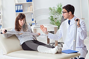 The doctor examining patient with broken leg