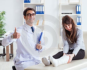 Doctor examining patient with broken leg