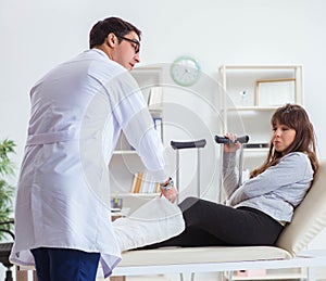 Doctor examining patient with broken leg