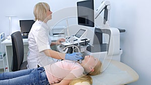 Doctor examining patient child girl thyroid gland using ultrasound scanner.