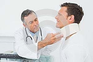 Doctor examining patient at desk in office