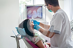 Doctor examining patient`s teeth with intraoral camera