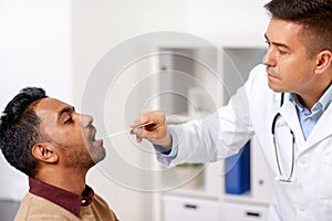 Doctor examining patient throat at clinic