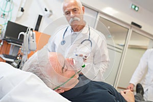 Doctor examining patient wearing oxygen mask