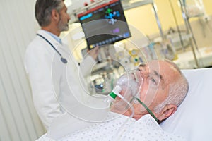 Doctor examining patient wearing oxygen mask