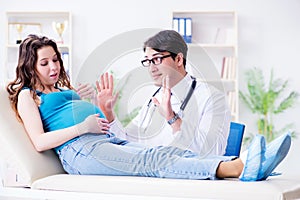 The doctor examining pregnant female patient in hospital