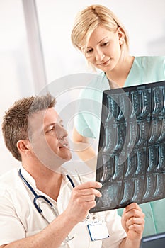 Doctor examining x-ray image with nurse