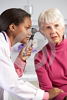 Doctor Examining Senior Female Patient's Ears