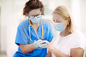 Doctor examining sick patient. Ill woman in clinic