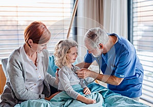 Doctor examining a small hospitalized girl with mother in hospital.