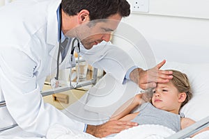 Doctor examining temperature of ill girl