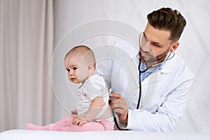 Doctor Examining Toddler Listening To Lungs With Stethoscope In Clinic