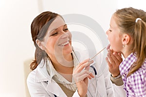 Doctor examining with tongue depressor photo