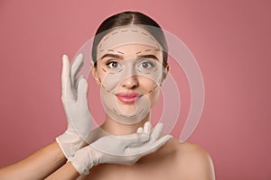 Doctor examining woman`s face before plastic surgery on background