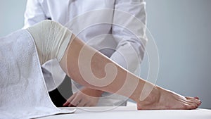 Doctor examining womans bandaged leg, venous varices, first aid for injuries photo